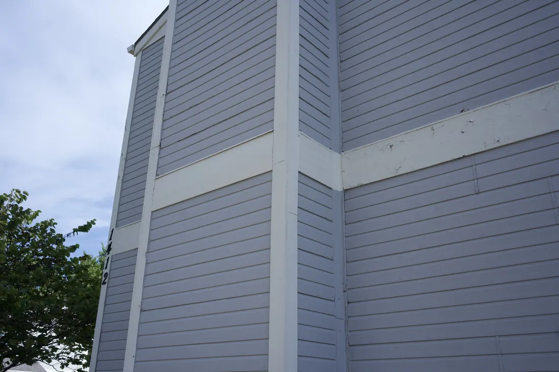Lap siding pulling apart along a seam above a trim board