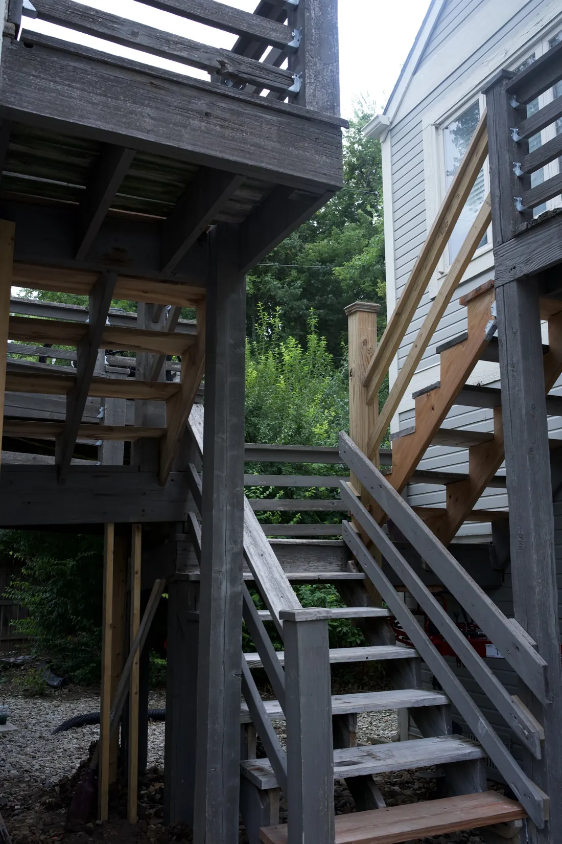 Weathered timber stair tower and landing framing on an apartment block before the rebuild