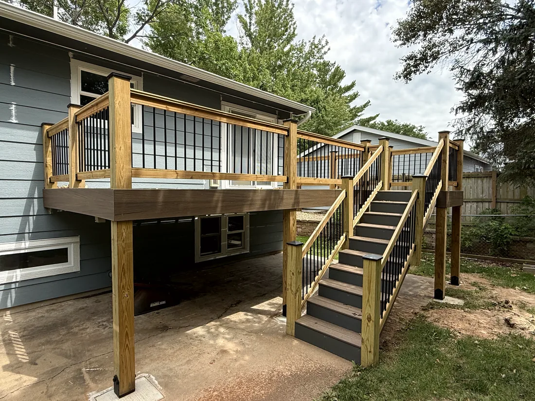 Cedar framed deck over a patio with a composite stair run down to the yard