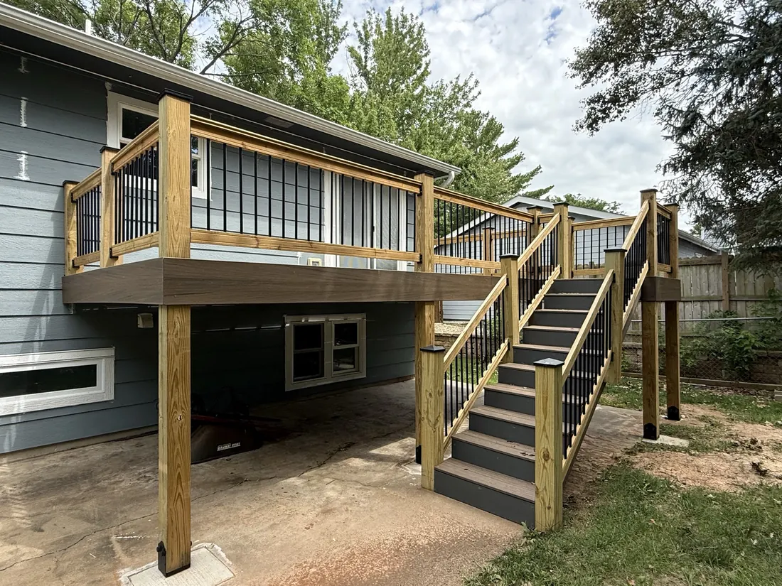 Cedar framed deck and full stair run across the back of a blue clad home