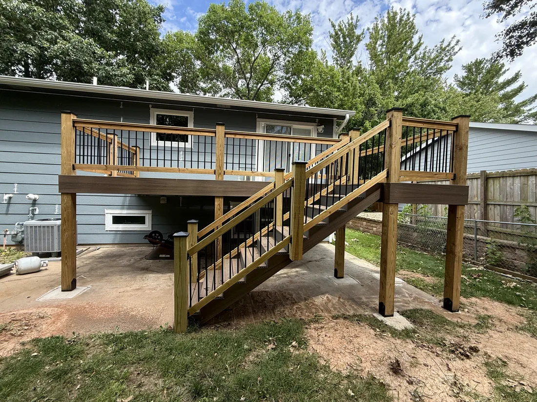 Deck posts and footings carrying an elevated deck above a concrete patio