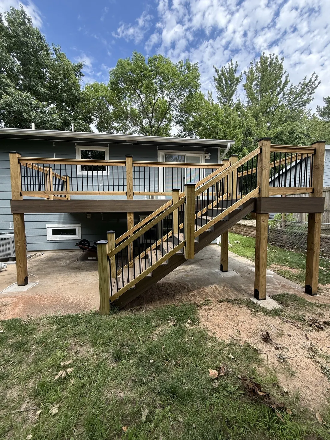 Posts, beams and framing carrying an elevated deck above a concrete pad