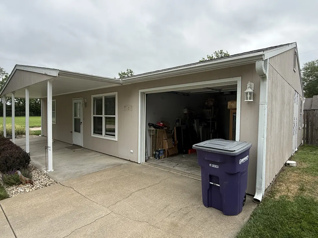 Open garage and carport with the original siding still in place