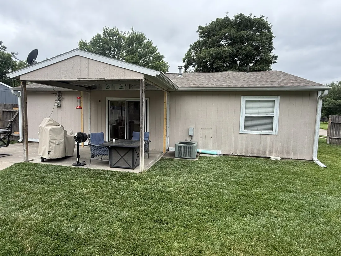Full rear elevation in stained vertical siding before the recladding