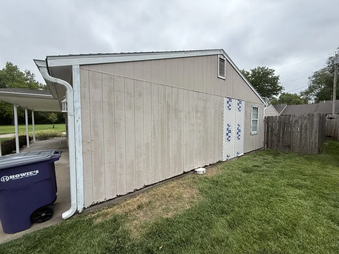 Weathered garage wall and downspout before new lap siding was fitted