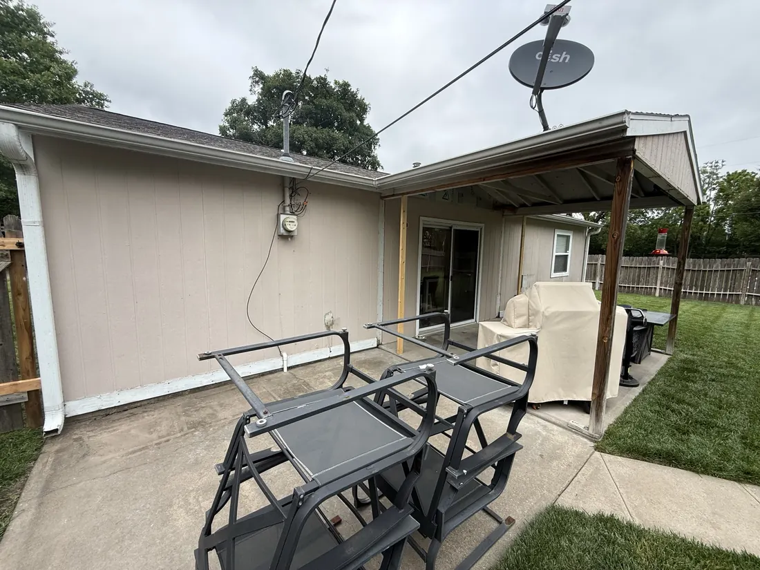 Corner of the covered patio with the original siding and timber posts