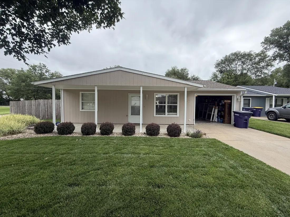 Ranch home from the street in weathered vertical siding before the siding replacement
