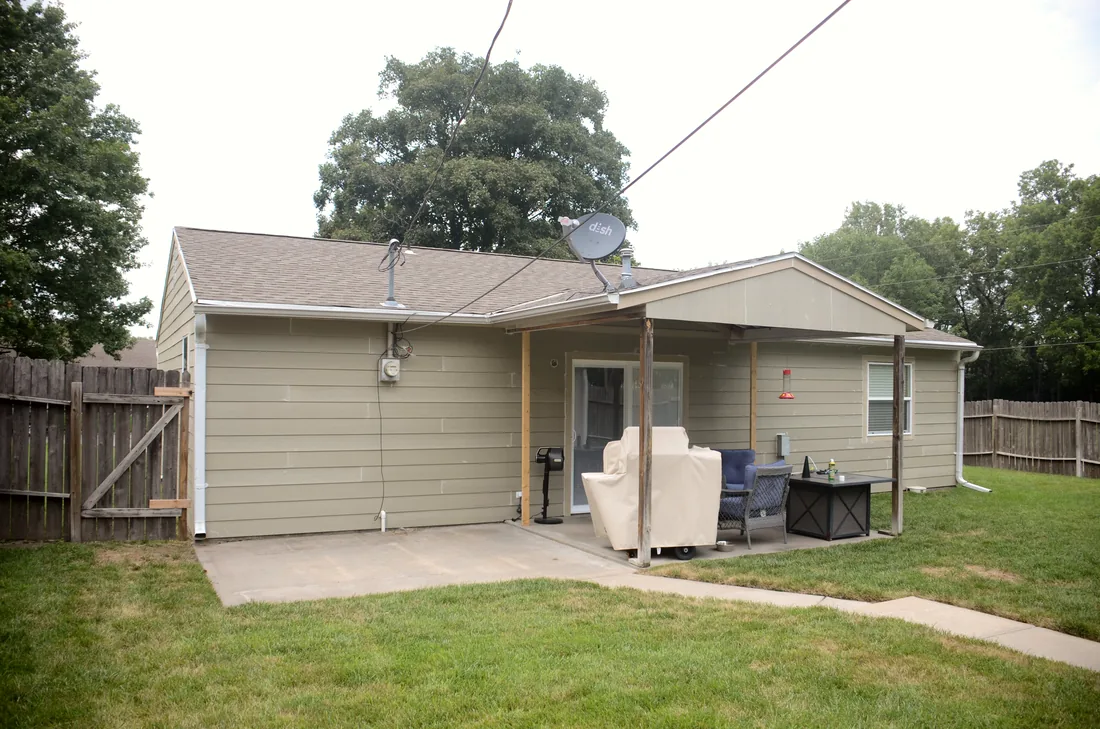 Back of a house finished in new lap siding, seen across the yard