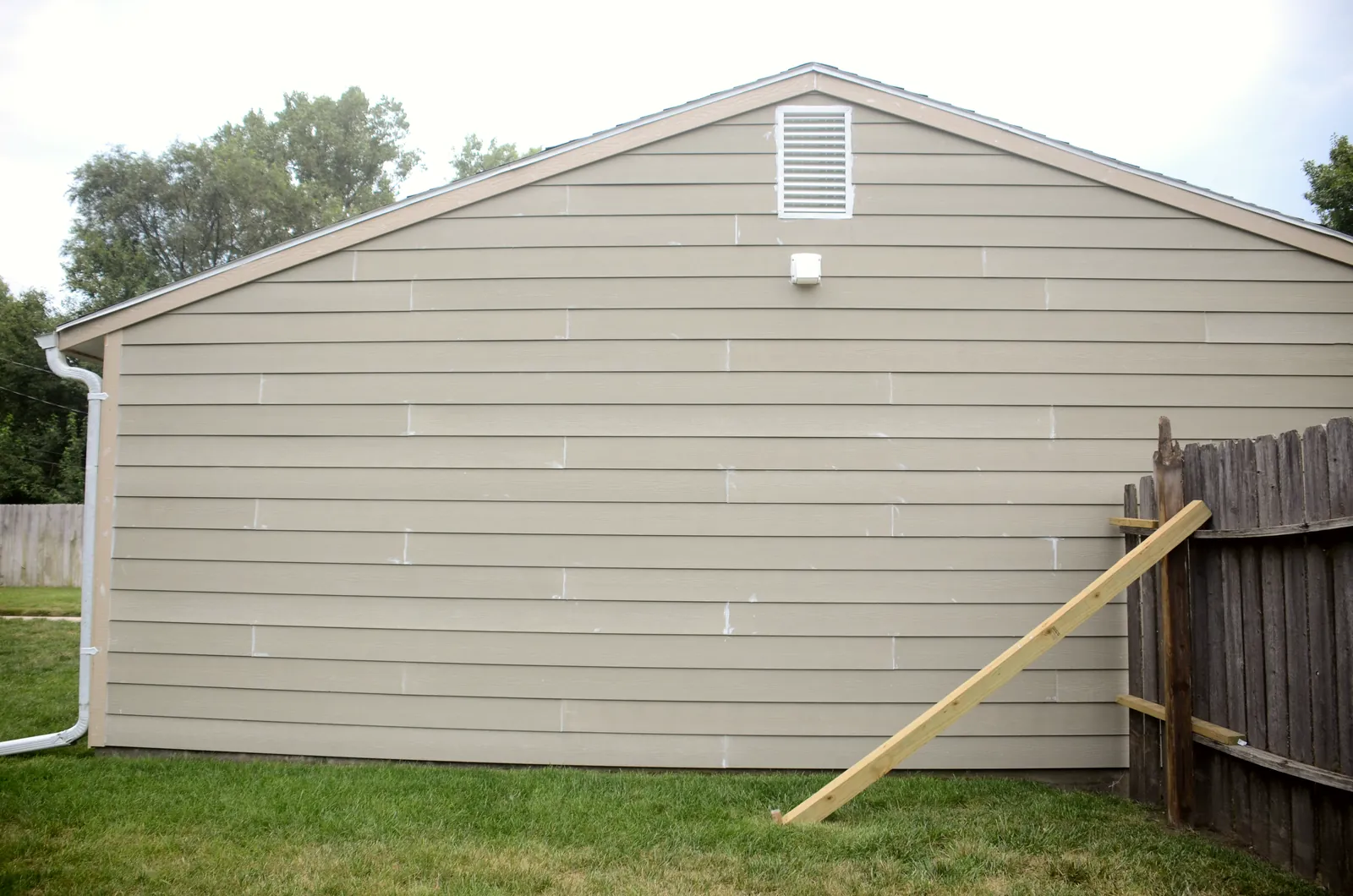 The same gable end finished in new lap siding with a fresh gutter line