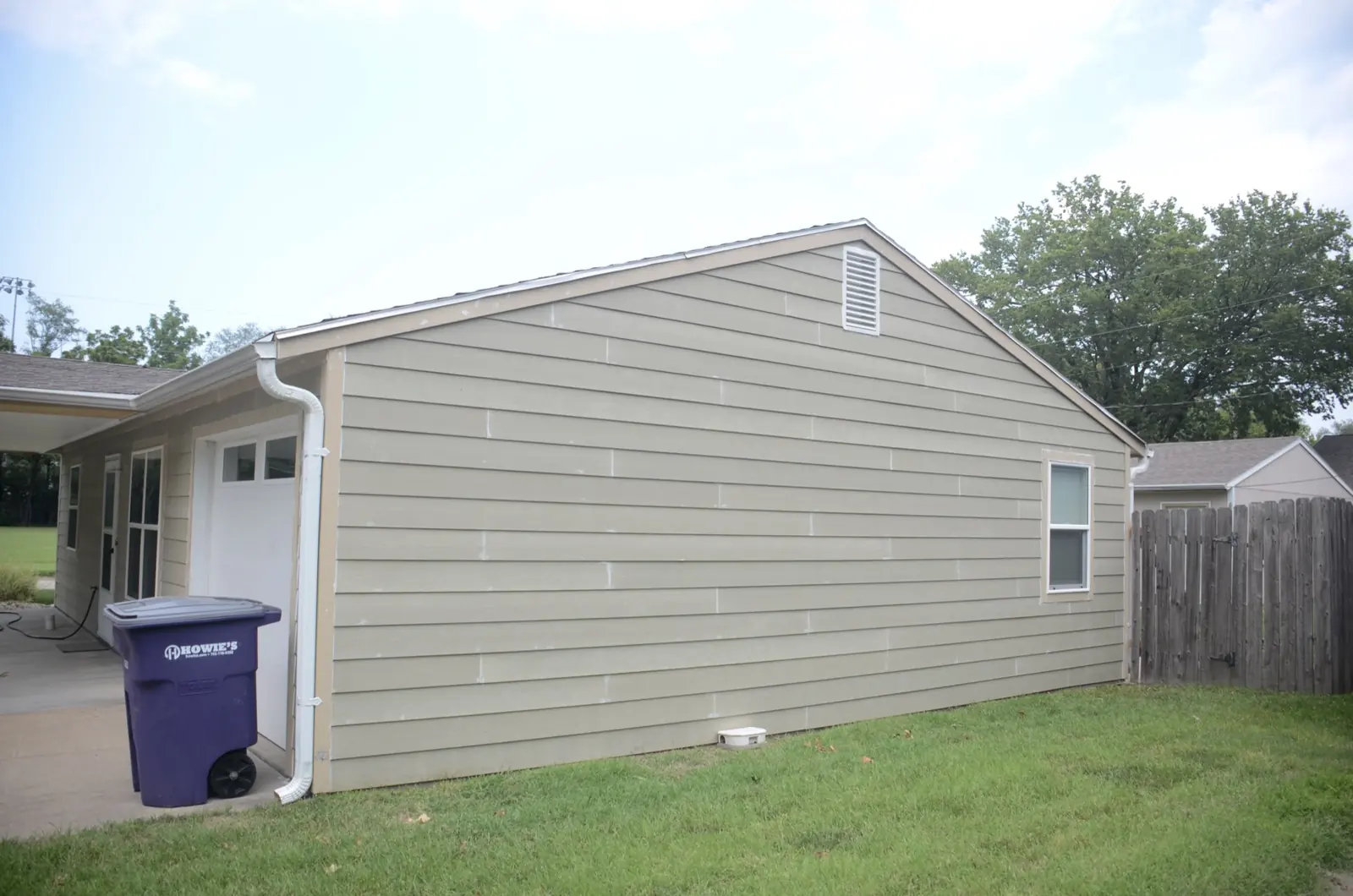 The same garage end wall finished in new lap siding with a replaced gutter line