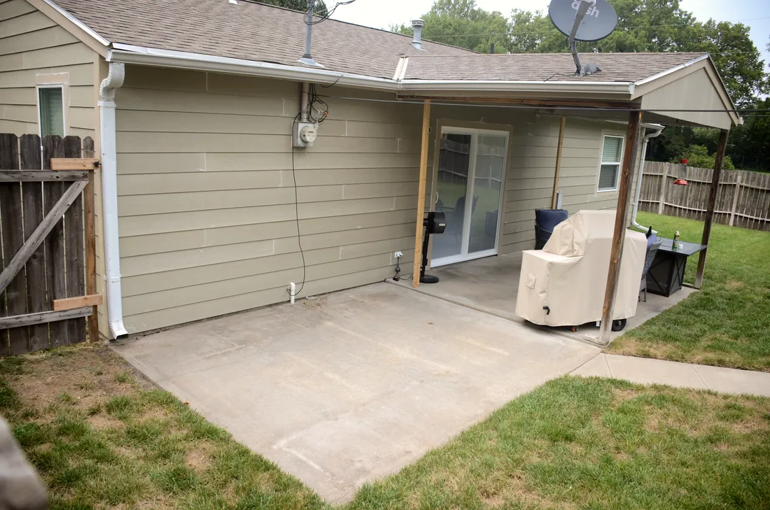 New lap siding along a covered patio at the back of a reclad home