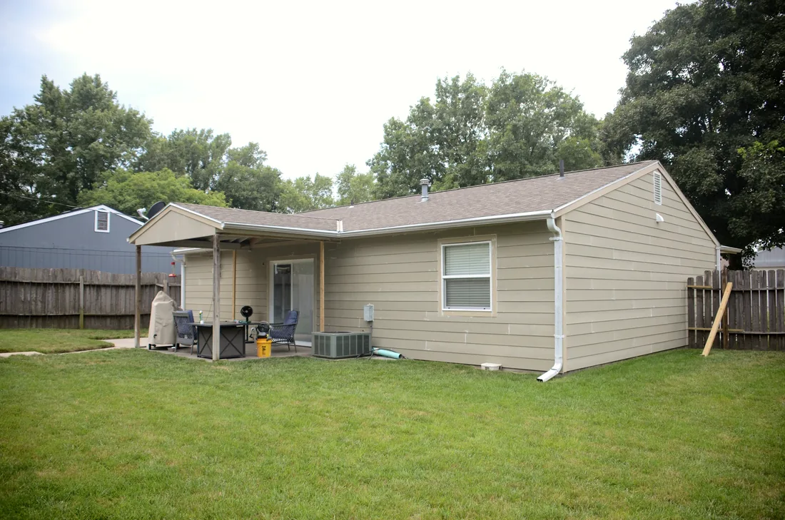 Rear elevation of a home reclad in new lap siding with white trim and gutters