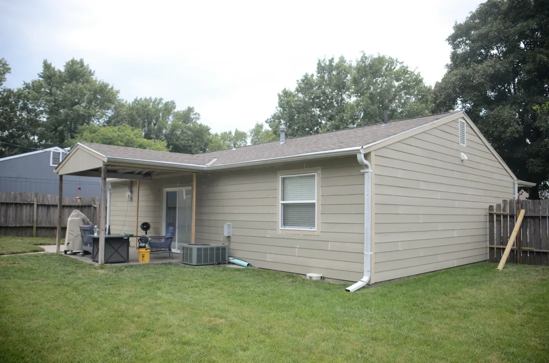 Side elevation of a reclad ranch home in new lap siding and white trim