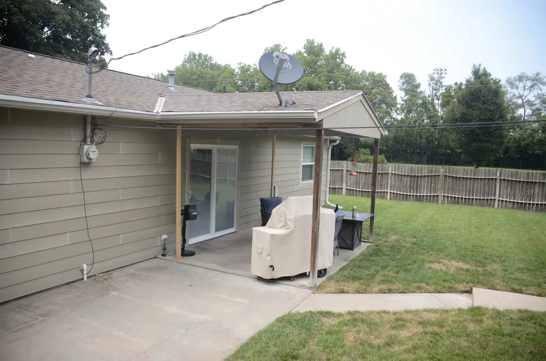 Reclad rear elevation seen from the back yard with new siding and gutters