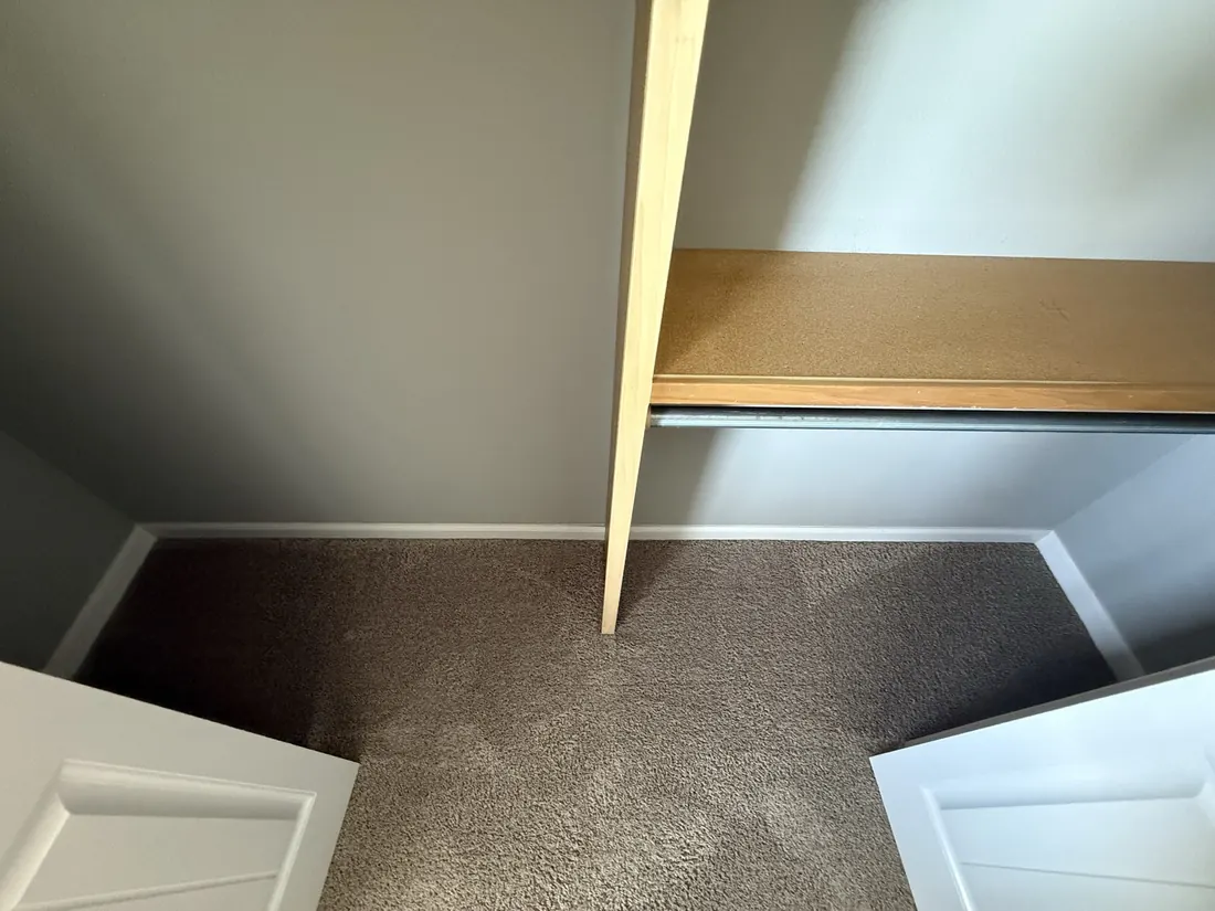 Carpet finished under a closet shelf and hanging rail