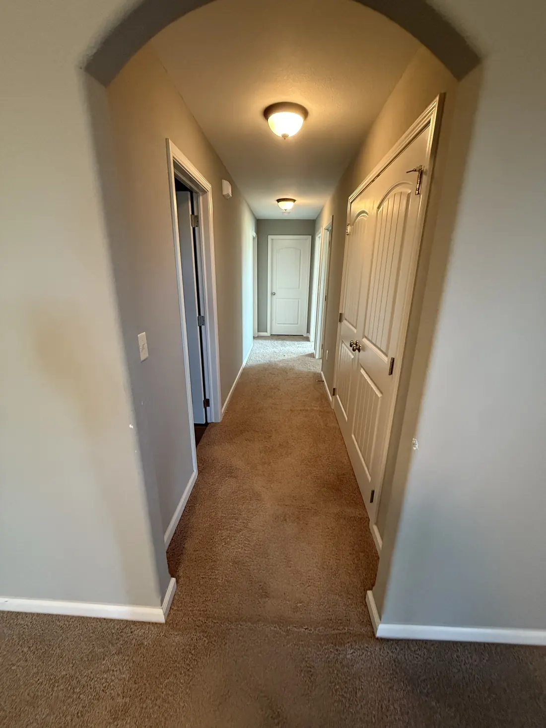 Carpet running the length of a hallway to the far bedrooms