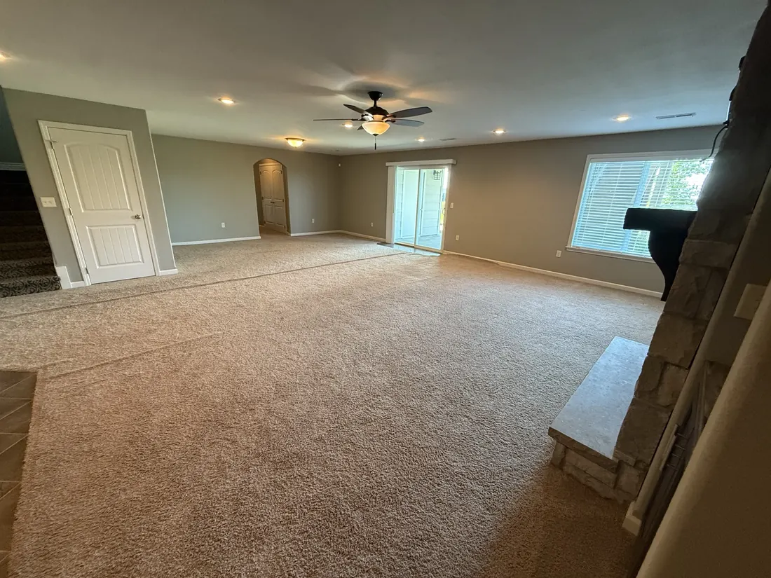 New carpet laid through a living room up to the fireplace