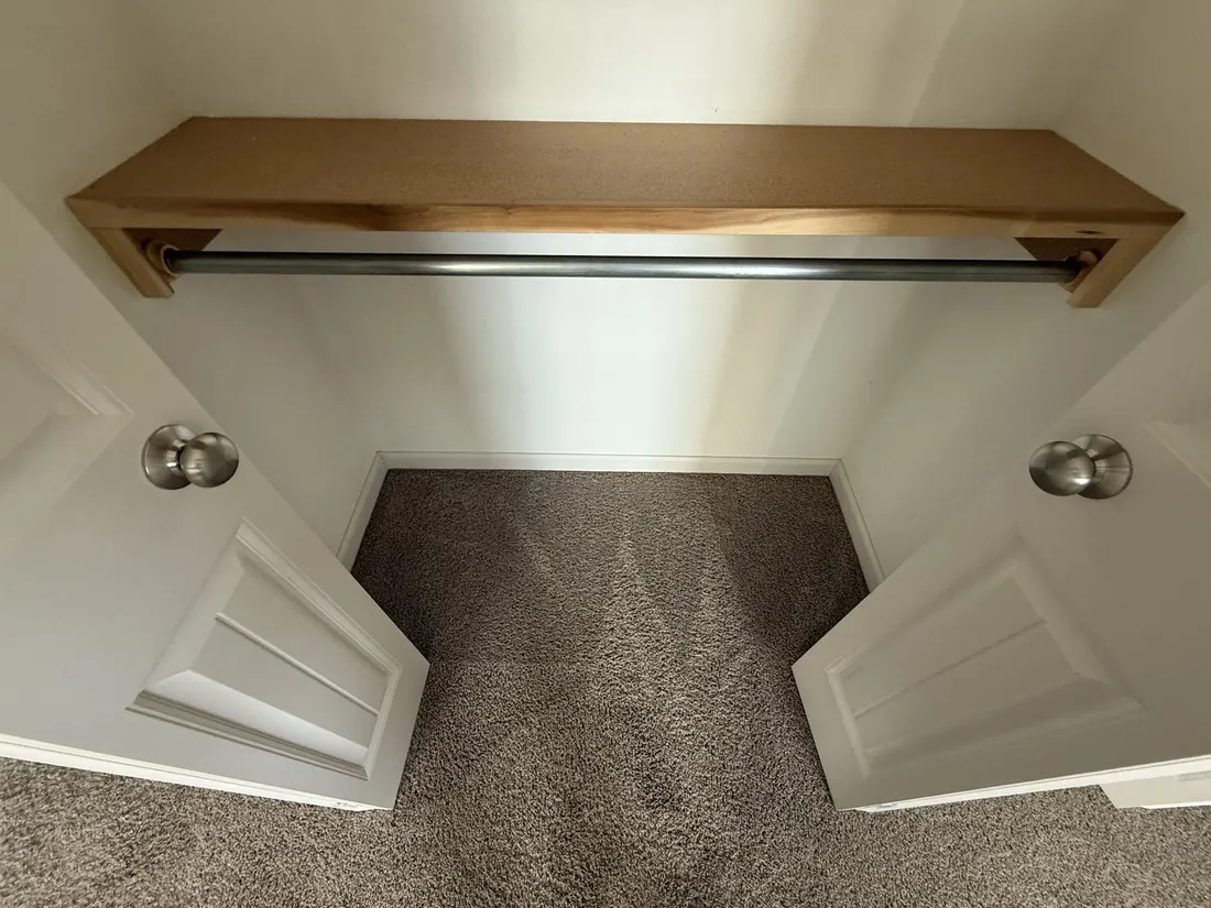 Carpet laid through to a built in wardrobe with a hanging rail