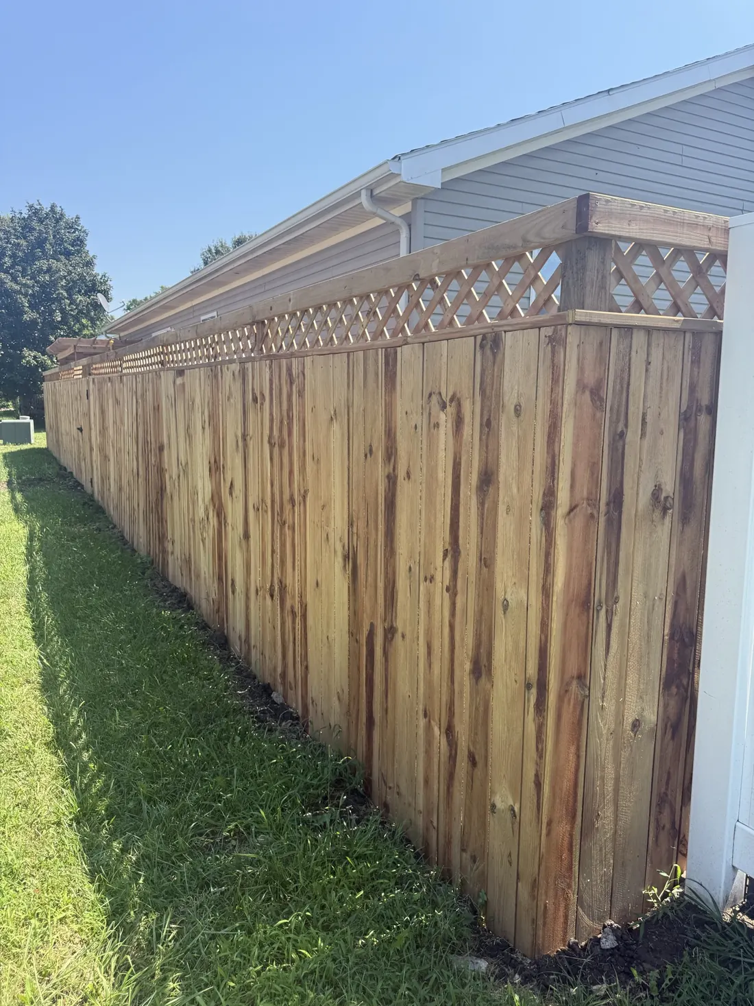Cedar fence running past the gable end of a home