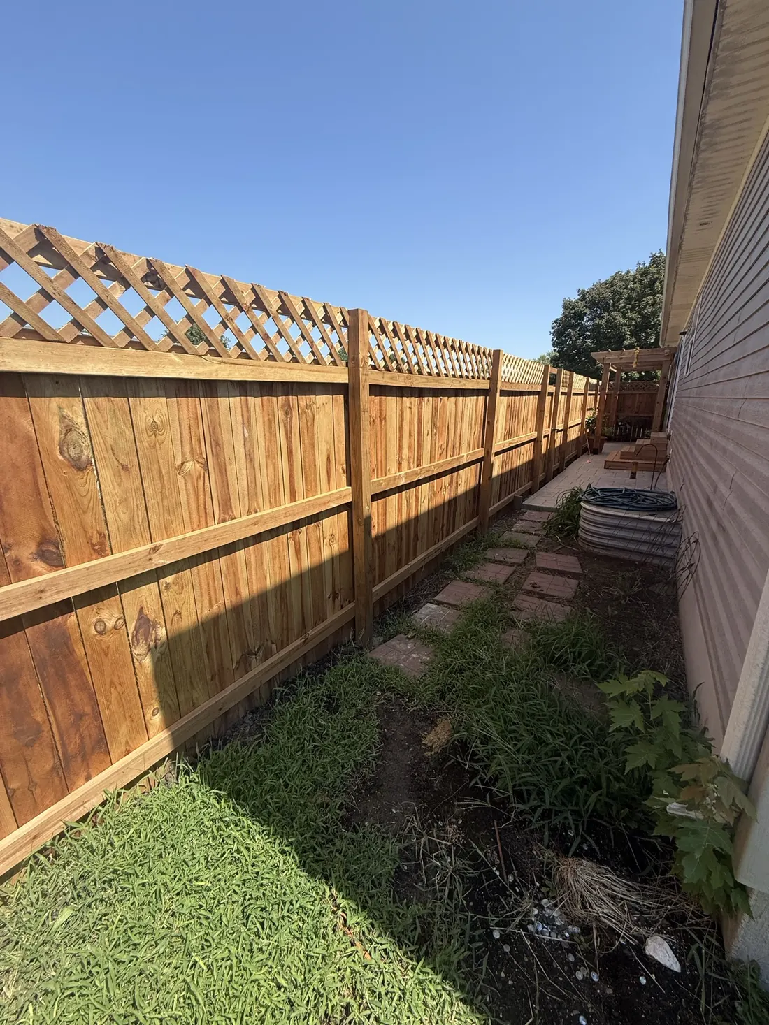 Cedar fence alongside a timber walkway and planting bed