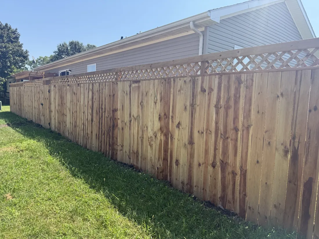 Wide view of a completed cedar privacy fence and lawn