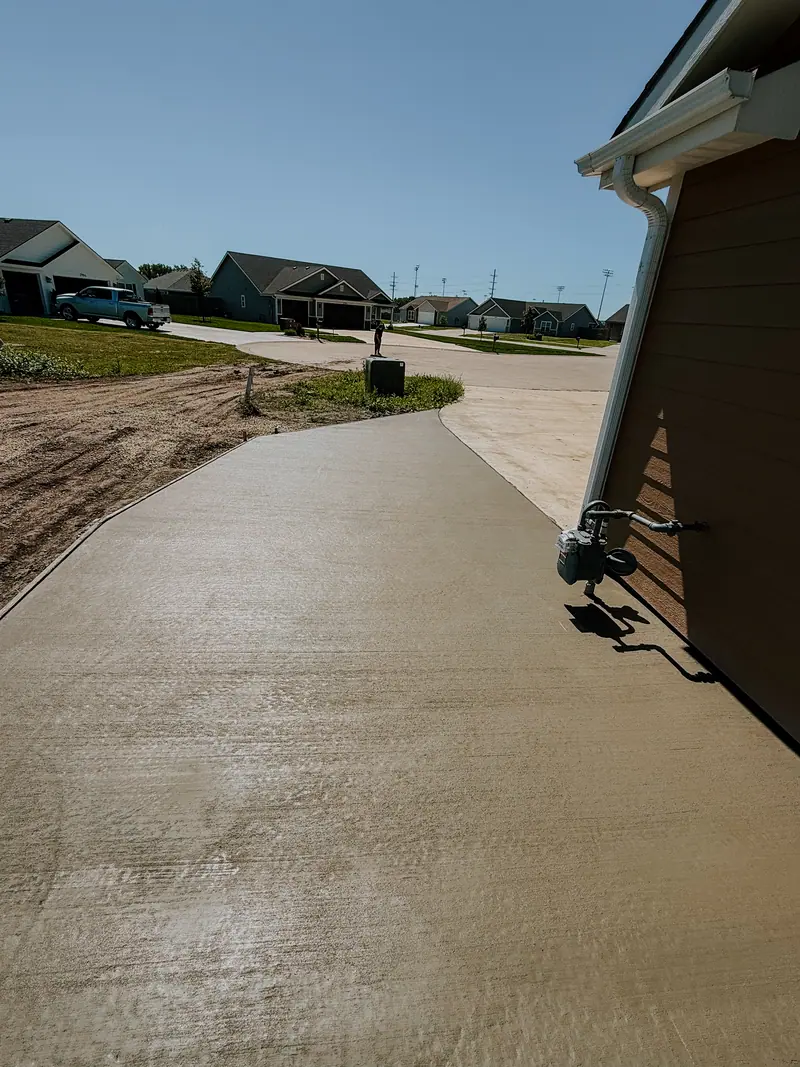 Finished concrete driveway running alongside a new house