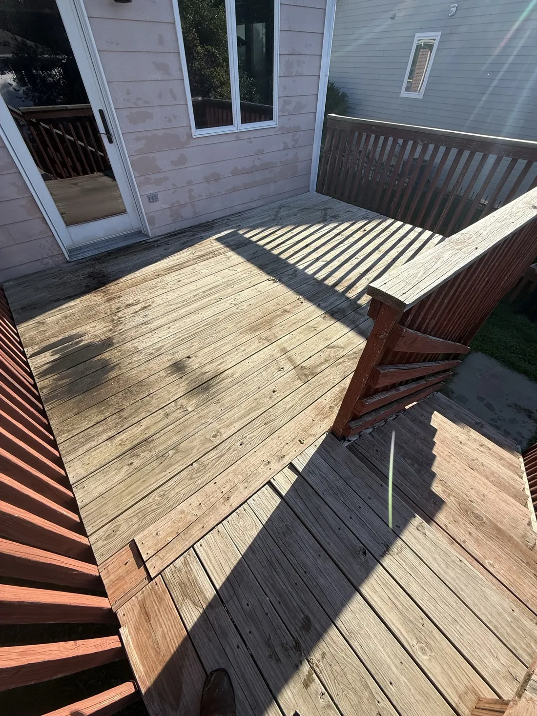Fresh decking laid against the restained railing and posts