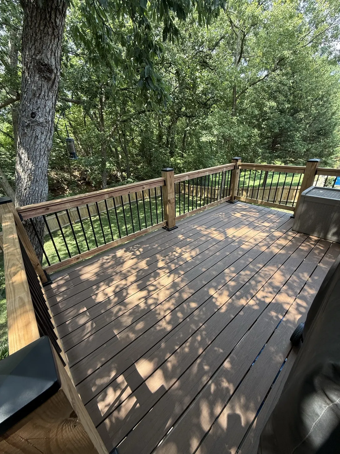 Restained deck and railings sitting under mature trees