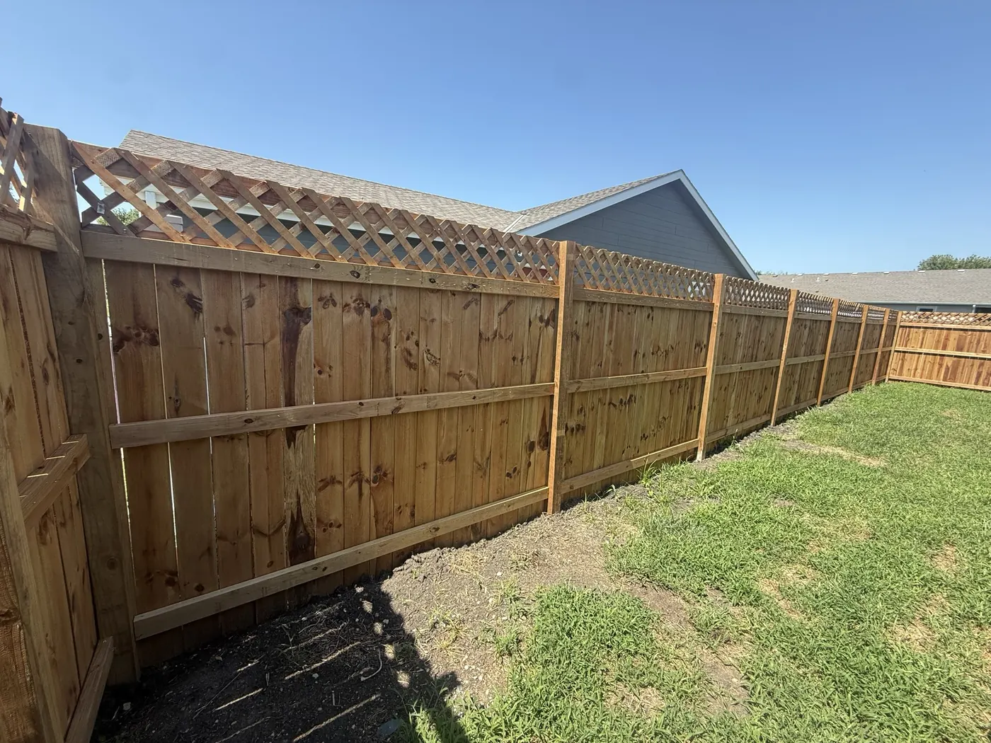 The same boundary after a new cedar privacy fence with a lattice top went in