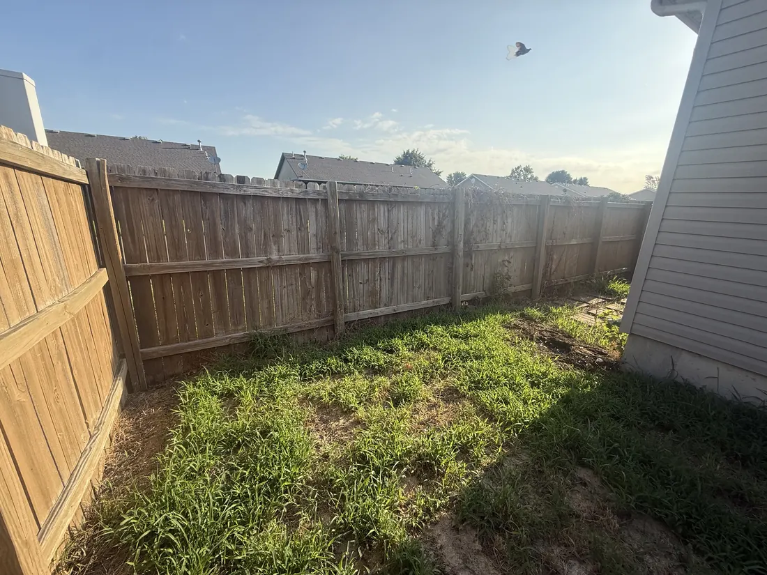Weathered fence panels sagging along the boundary before the new fence went in