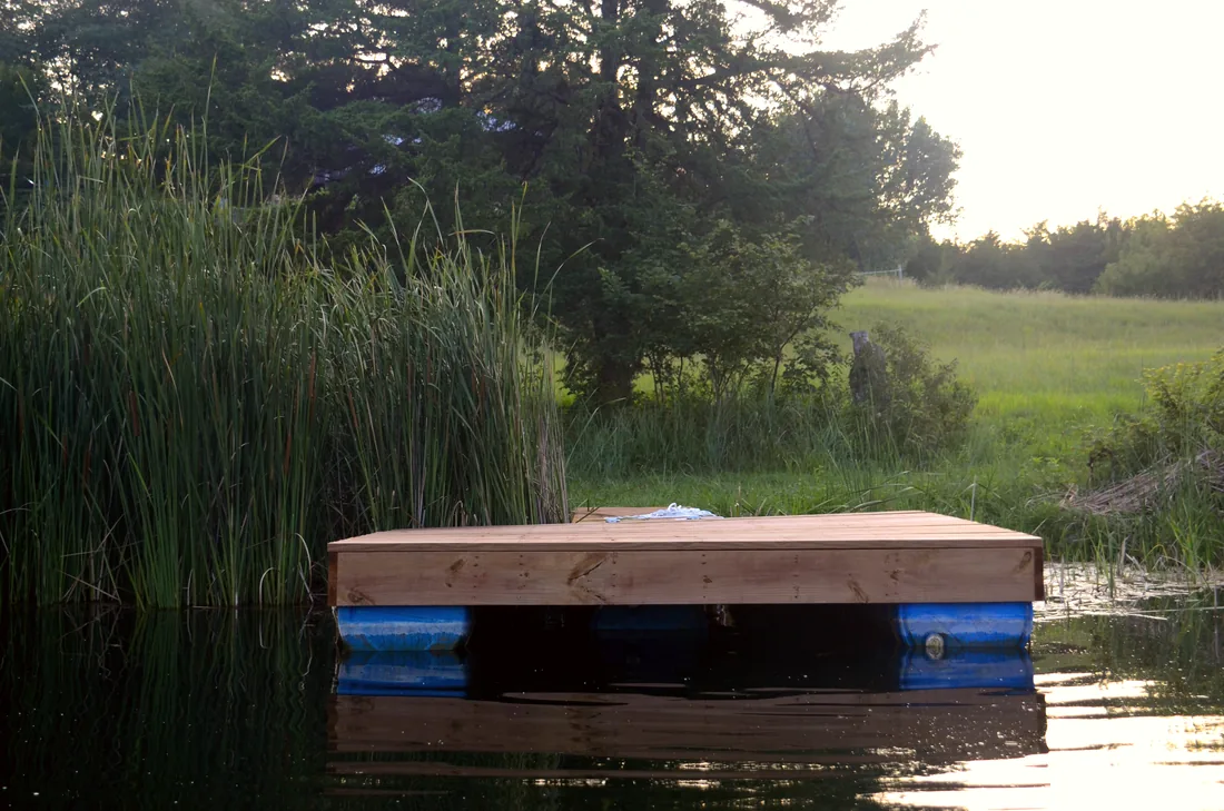 Cedar deck surface of a finished floating dock sitting level on the water