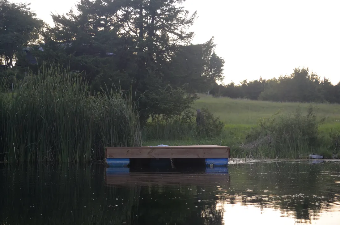 Cedar floating dock sitting out on still water in the evening