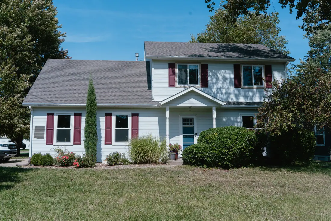 Repainted two story home exterior with red shutters