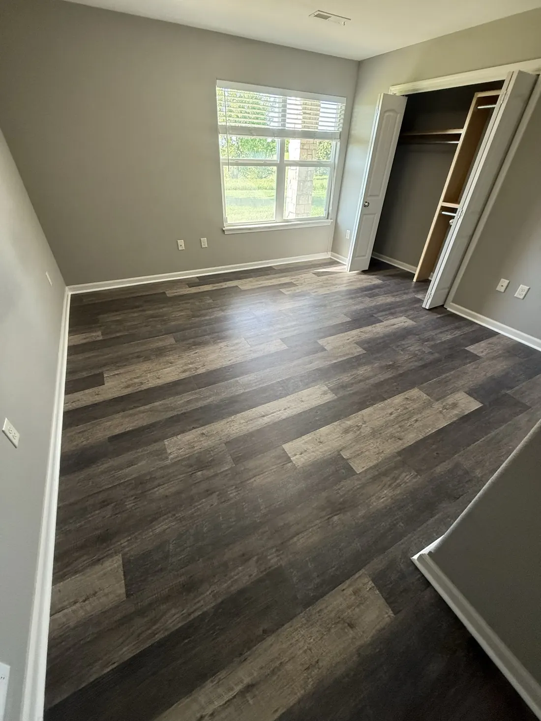 Bedroom in plank flooring with light across the boards from the window