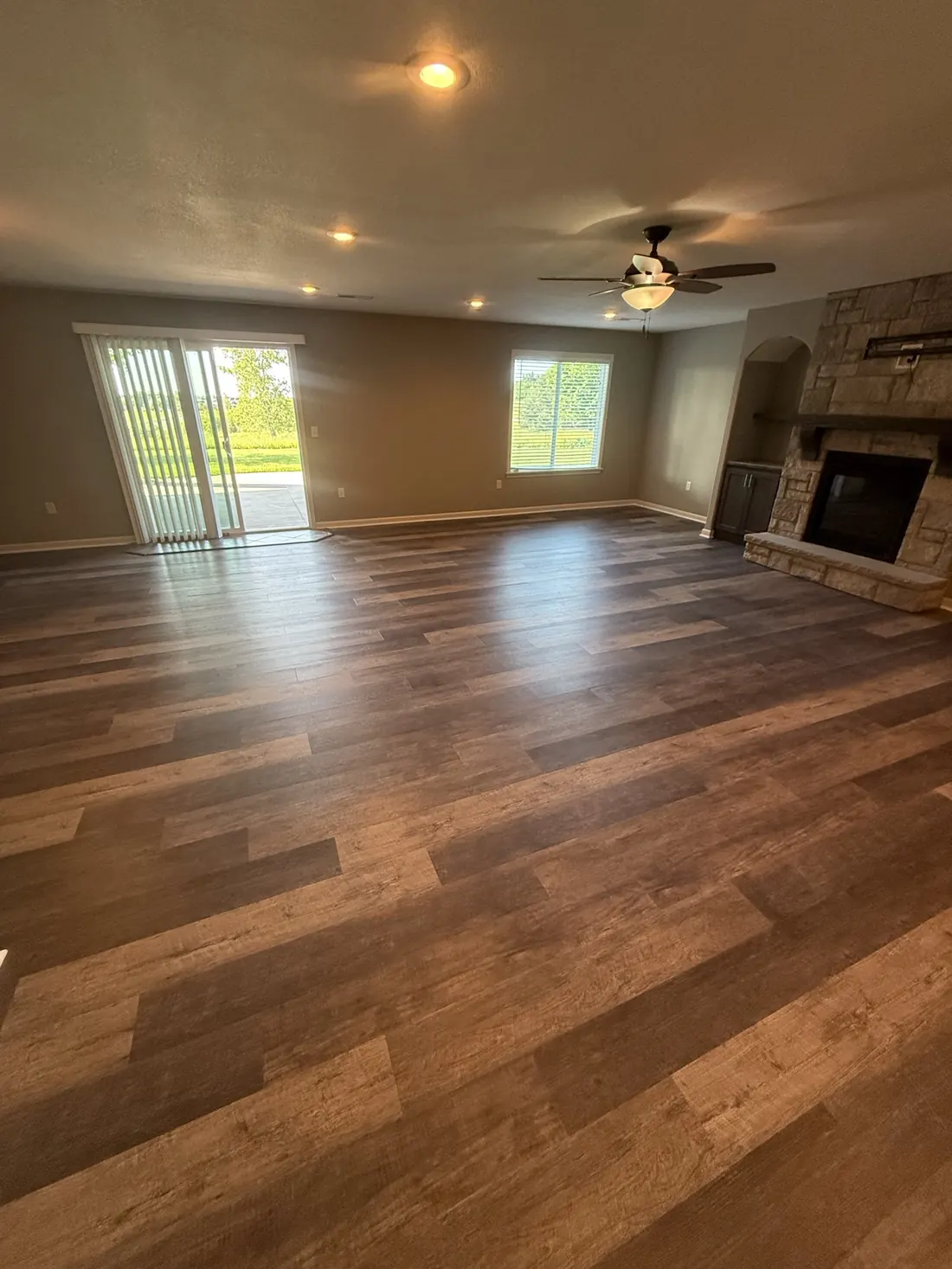 Wide plank flooring running the length of a lit hallway