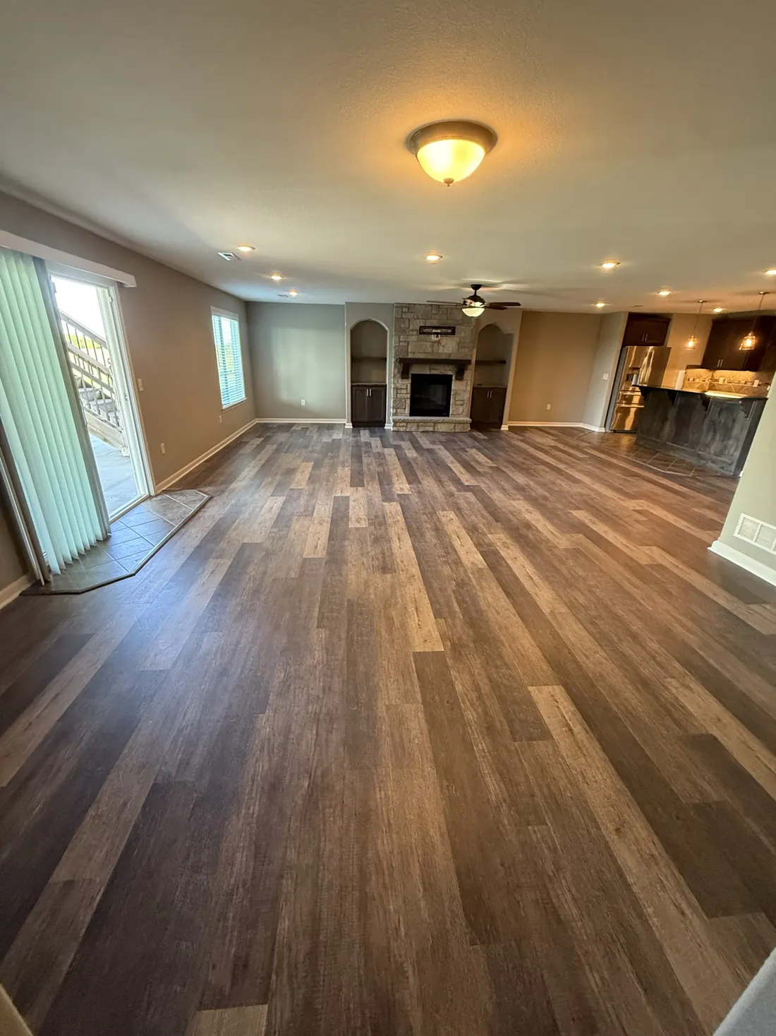 New plank flooring meeting the stair run beside the kitchen
