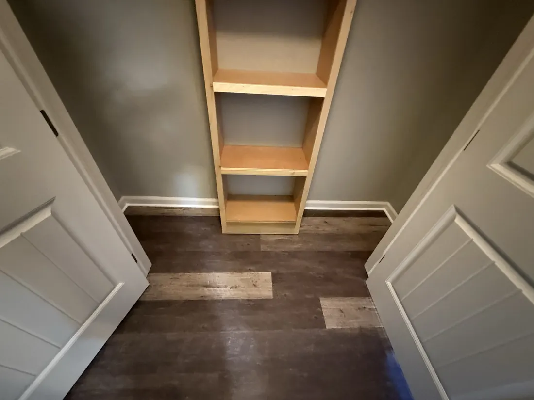 Plank flooring carried into a shelved linen closet