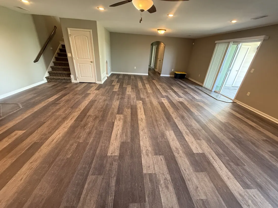 Open living room in plank flooring with the stair run behind
