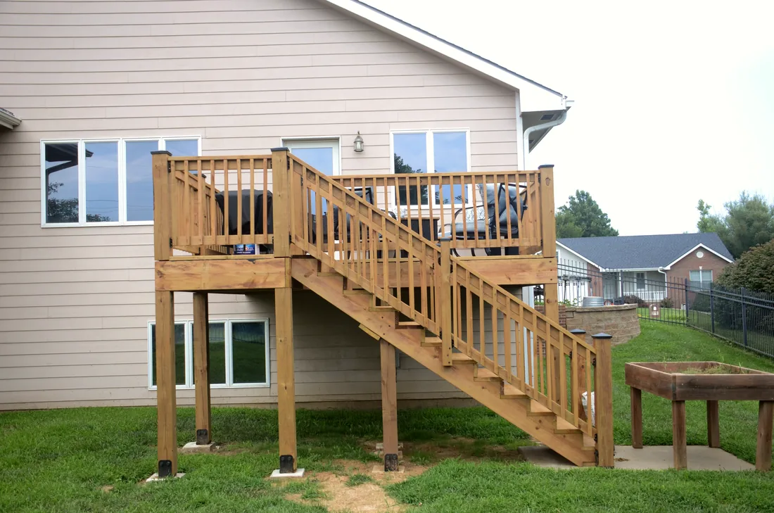 Cedar deck and stair run seen along the back of a two story home