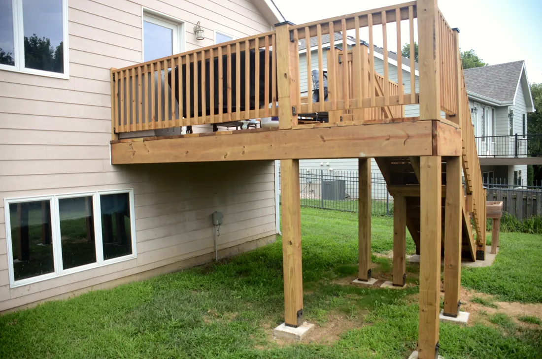 Cedar deck carried on posts and footings, showing the framing under the deck