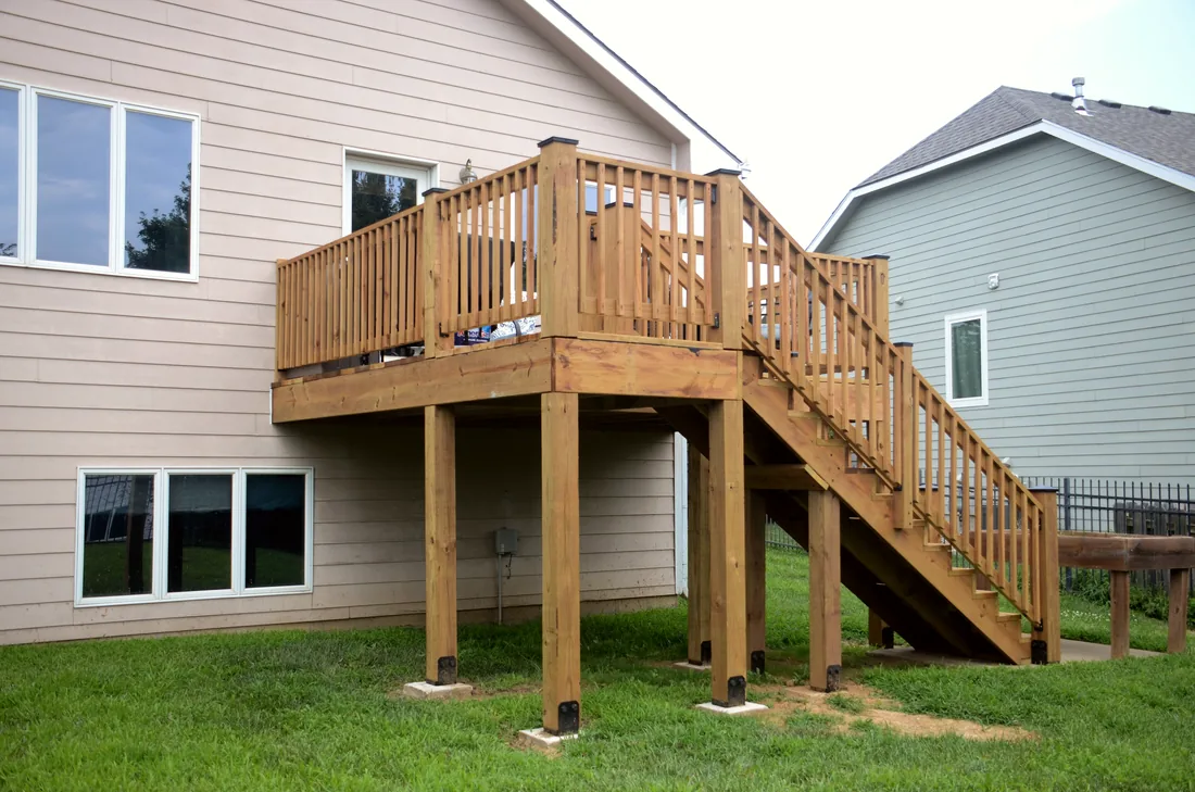 Elevated cedar deck with a full run of stairs on a two story Kansas home