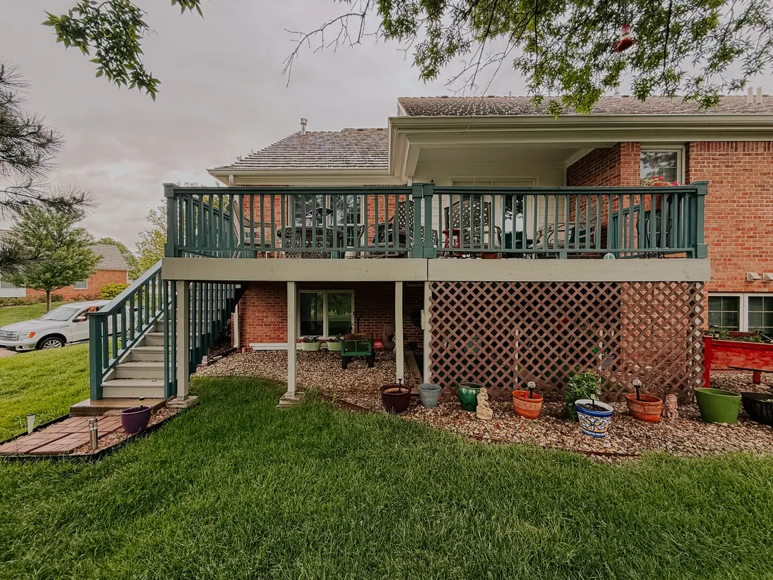 Second story deck with painted railings on a brick home
