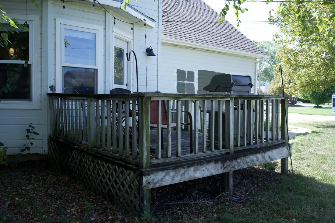 Grey weathered deck railing and boards due for replacement