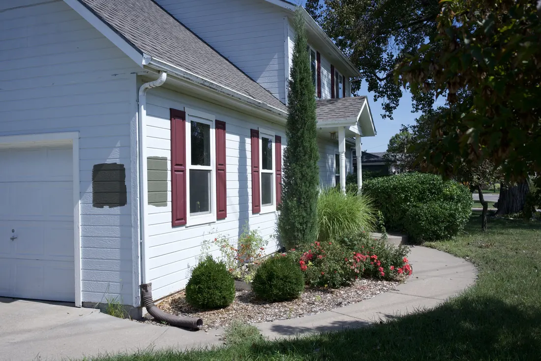 White lap siding and shutters running along the front walk
